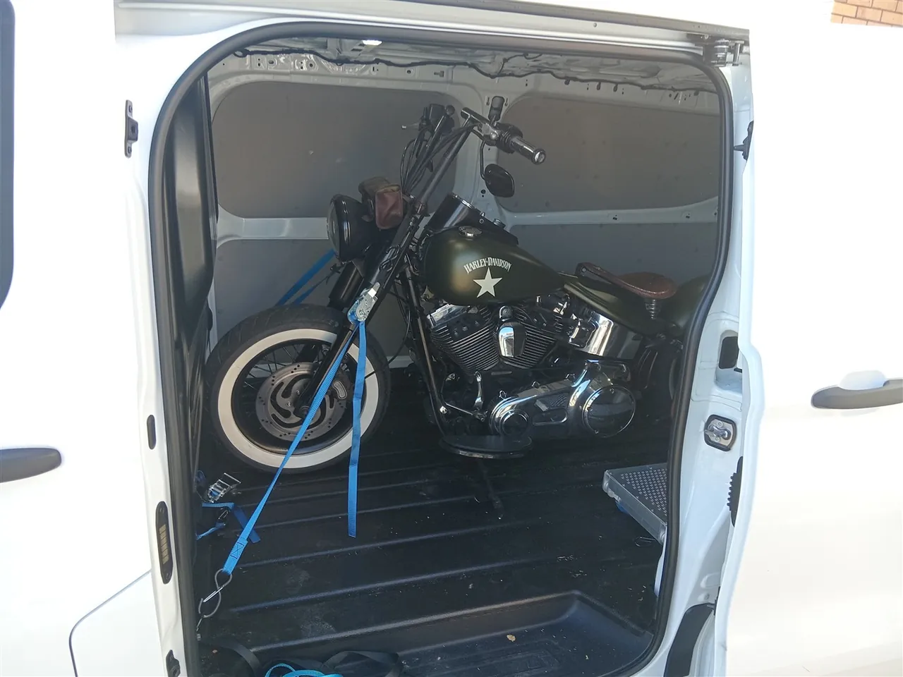 Green Harley-Davidson inside the enclosed transport van