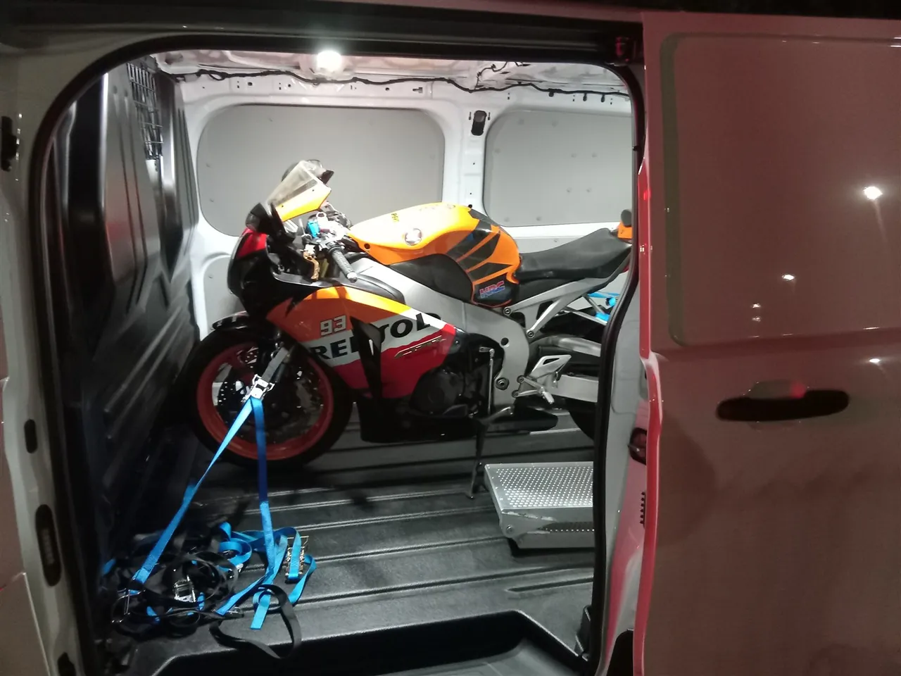 Orange Honda sports motorcycle inside the van at night